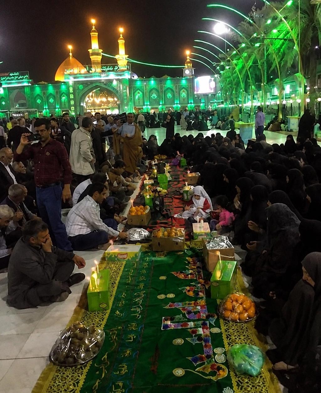 خادمان در حال چیدن نان و خرما روی سفره

